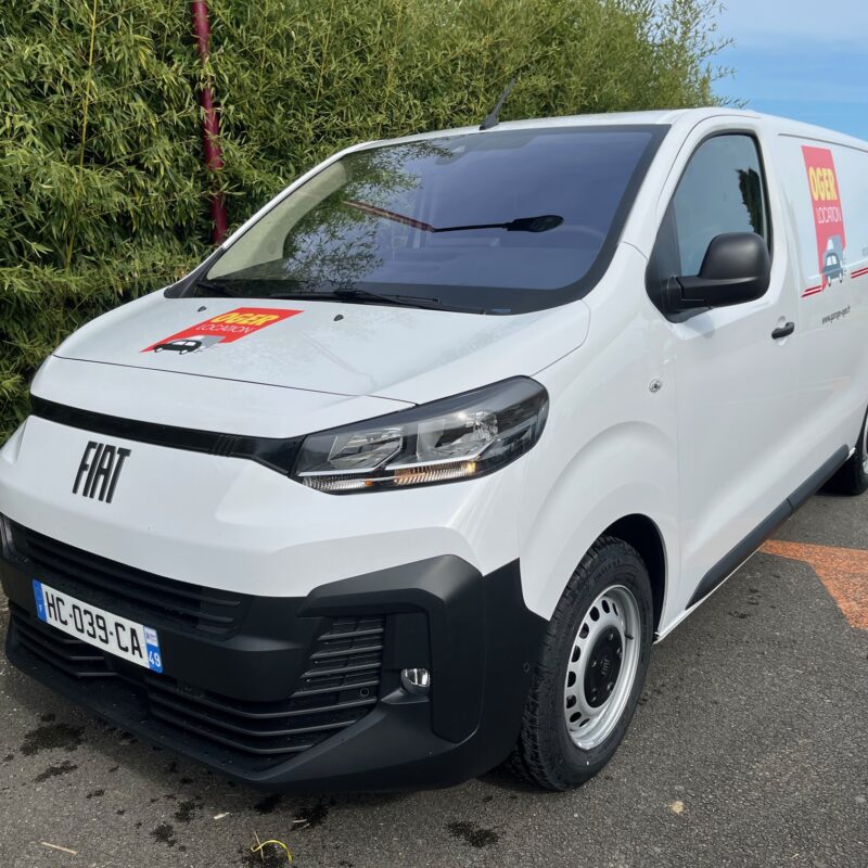 Camionnette blanche Fiat stationnée sur le parking.